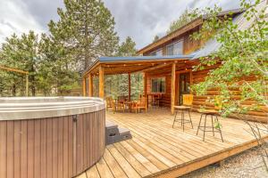 a wooden deck with a hot tub and a house at Whittier Cabin in Three Rivers