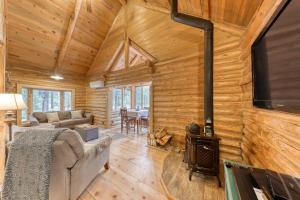 a log cabin living room with a woodburning stove at Whittier Cabin in Three Rivers