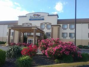 a hotel with pink flowers in front of a building at Baymont by Wyndham Evansville North/Haubstadt in Haubstadt
