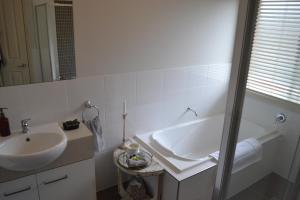 a white bathroom with a sink and a mirror at Gone to Barossa in Tanunda