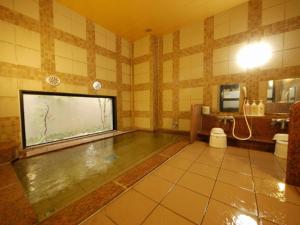 a large bathroom with a large aquarium in the wall at HOTEL ROUTE-INN Ota Minami -Route 407- in Ota