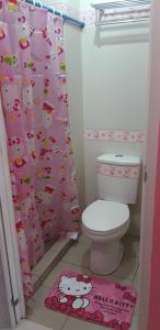 a bathroom with a hello kitty shower curtain and a toilet at Hello Kitty at Wind Residences Tagaytay in Tagaytay