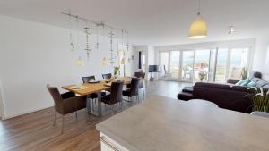a dining room and living room with a table and chairs at Seesichtpur Wohnung Kaiser in Pelzerhaken