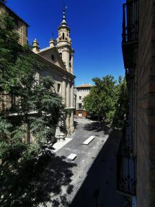 eine leere Gasse mit einem Uhrturm im Hintergrund in der Unterkunft AZ El Balcón de San Felipe in Saragossa