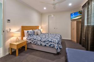 1 dormitorio con 1 cama y TV. en Pavillions on Hamilton Island by HIHA, en Hamilton Island