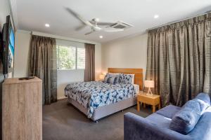 a bedroom with a bed and a couch at Pavillions on Hamilton Island in Hamilton Island