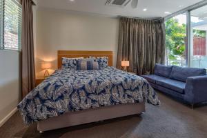 a bedroom with a bed and a blue couch at Pavillions on Hamilton Island in Hamilton Island