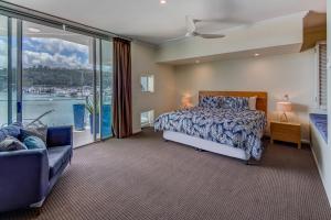 a bedroom with a bed and a large window at Pavillions on Hamilton Island by HIHA in Hamilton Island
