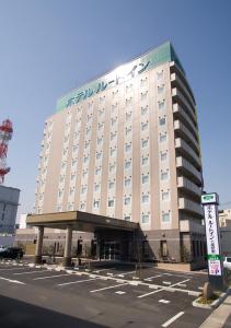 un gran edificio con un cartel delante en Hotel Route-Inn Nanao Ekihigashi, en Nanao