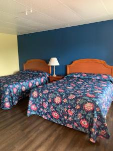 Baw Beese Inn في Hillsdale: سريرين في غرفة نوم بجدران زرقاء