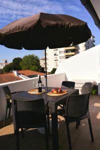 una mesa con sombrilla y una botella de vino en Terraço da Boavista en Oporto