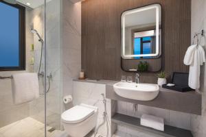 新加坡Citadines Balestier Singapore的带水槽、马桶和镜子的浴室
