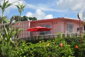 een rode paraplu voor een roze gebouw bij Old American House K-113 in Ginowan
