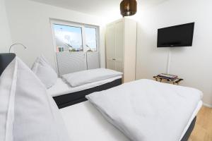 um quarto branco com 2 camas e uma televisão em Casa Gran Canaria em Olpenitz