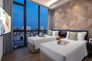 新加坡Citadines Balestier Singapore的有两张床和一扇大窗户的酒店房间
