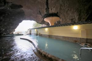 una gran piscina en una cueva con un túnel en Hotel Urashima en Katsuura