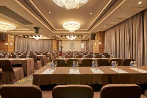 a conference room with tables and chairs and a chandelier at Athena Hotel in Ho Chi Minh City