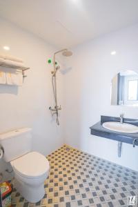 a bathroom with a toilet and a sink at LUFFY Hotel in Bí Giàng