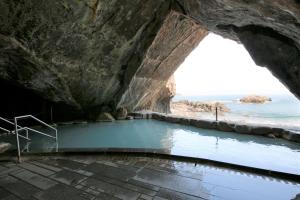 uma piscina numa gruta junto ao oceano em Hotel Urashima em Katsuura