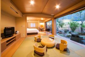una habitación con una cama y una ventana grande en Okuyado Buaiso, en Yufu