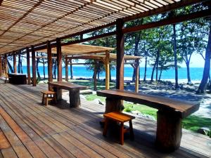 a pavilion with benches and a view of the ocean at The Pade Dive Resort in Sabong