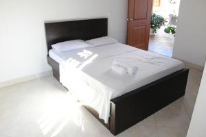 a bed with white sheets and towels on it at Hotel La Ceiba in Valparaíso