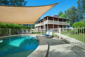 a swimming pool with a fence and a house at Elderslie House - Stunning Country House in Mitchells Flat