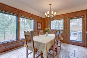 a dining room with a table and chairs and windows at Conifer Lane - Lovely Woodland Setting in Sunriver
