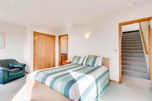 a bedroom with a bed and a stair case at Villa VilleKulla on the Oceanfront in Oceanside