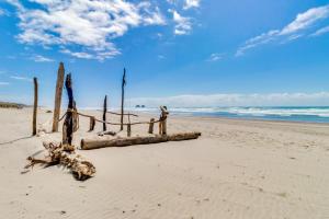 a beach with a bunch of logs on the sand at Surf's Edge in Rockaway Beach