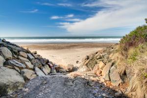 a beach with rocks and the ocean in the background at Neptune's Trident in Lincoln Beach