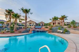 a swimming pool with a waterfall and palm trees at Mountain View Retreat: Paradise Village at Zion #39 in Santa Clara