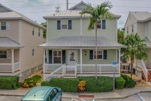 a house with a palm tree in front of it at Hemingway Hideaway in Stock Island