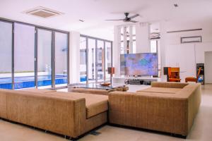 a living room with a couch and a tv at Villa Damar Canggu by Nagisa Bali in Canggu