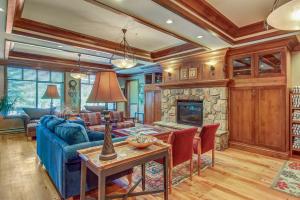 a living room with a blue couch and a stone fireplace at Powderhorn Lodge 223: Pennyroyal Suite in Solitude