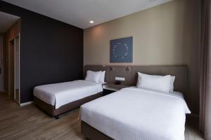 Postel nebo postele na pokoji v ubytování Qliq Damansara Hotel