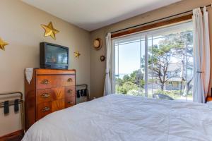 a bedroom with a bed and a tv and a window at Oregon Bed n' Beach in Holiday Beach