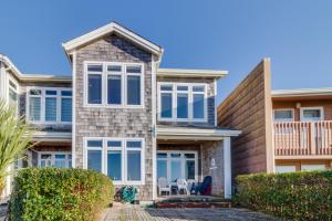 a house with windows and chairs in front of it at Surf's Edge in Rockaway Beach