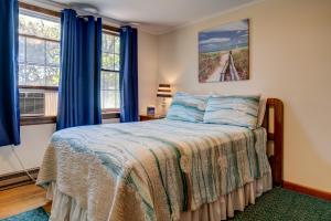 a bedroom with a bed and two windows at Nauset Beach Dream in Orleans