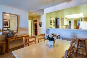 a dining room with a table with a vase of flowers on it at The Bridges 102 in Mammoth Lakes