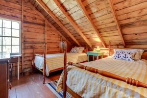 Un dormitorio con dos camas en una cabaña de madera. en The 1909 Cottage, en Boothbay Harbor