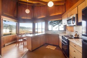 a kitchen with wooden cabinets and a dining room with a table at Curtis-Moulton Retreat in Sea Ranch