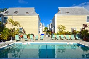 una piscina con sillas y una casa en Casa Havana @ Duval Square R22, en Key West