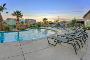 a swimming pool with lounge chairs and palm trees at Sunset: Paradise Village #50 in Santa Clara