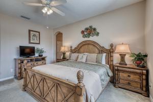 a bedroom with a wooden bed and a television at Windstar Villa in Davenport
