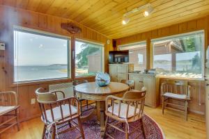 cocina y comedor con mesa y sillas en The Cabin At Penn Cove, en Coveland