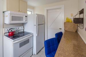 a kitchen with a white refrigerator and a microwave at Leeward Isle in Key West