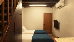 een kleine kamer met een bed en een televisie bij Casa Wisteria in Jincheng
