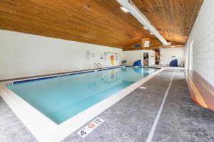 a swimming pool in a building with a wooden ceiling at Bay Point Lakefront 1B Down in Whitefish