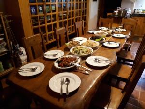 a long wooden table with plates of food on it at Villa del Carmen Haven Bohol in Carmen